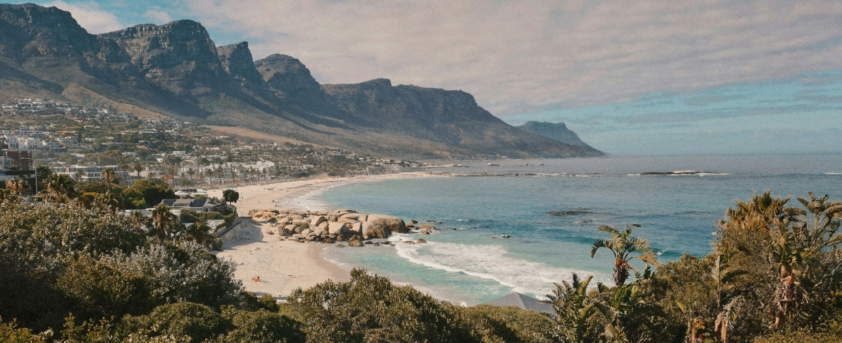 Coastal view of Camps Bay beach with mountains and turquoise water in Cape Town