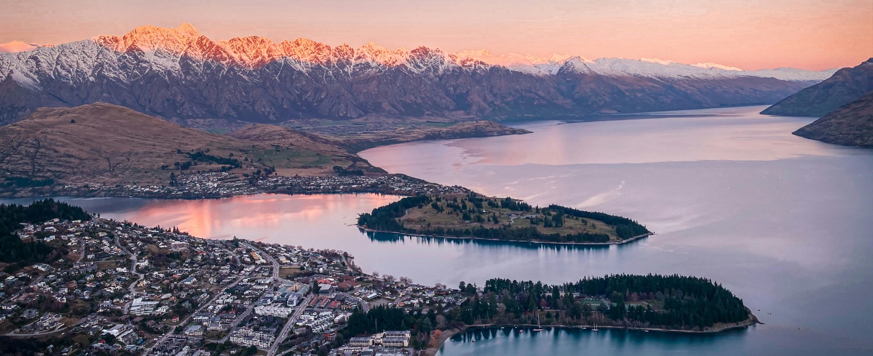 Aerial view of Queenstown and surrounding mountains at sunset